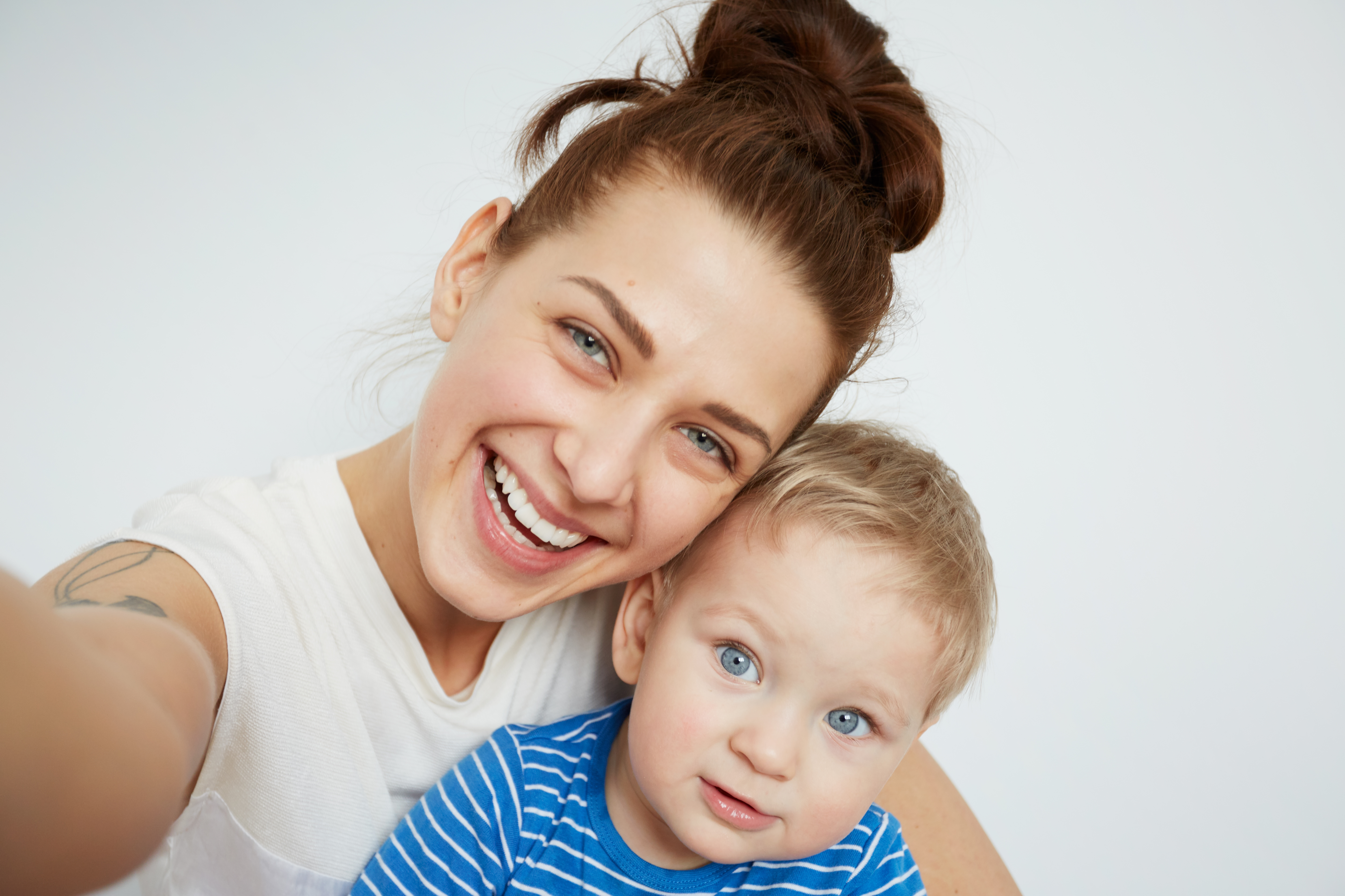 Young Mother With Her One Years Old Little Son Dressed In Pajamas Are